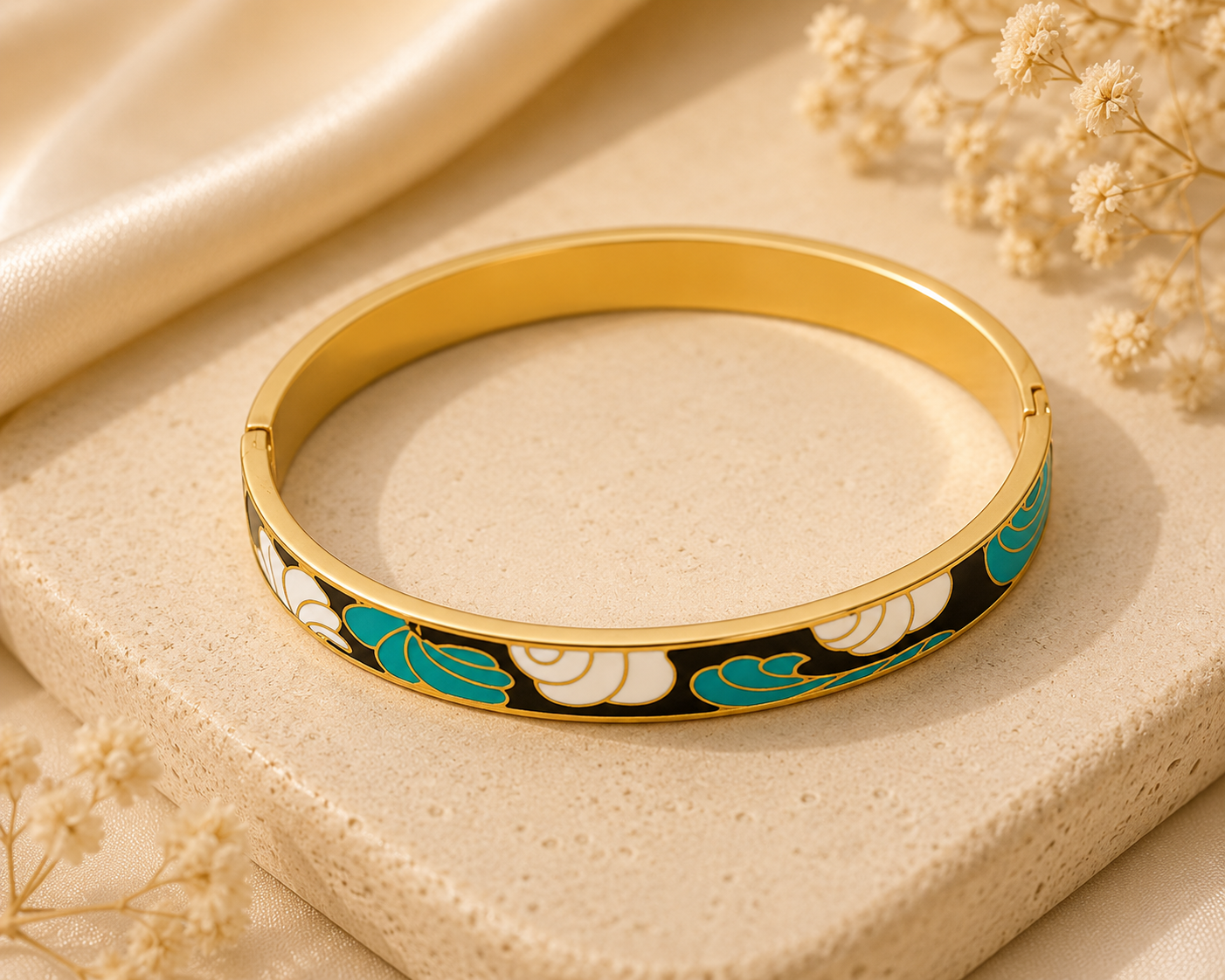 Gold bracelet with floral design on a beige surface with dried flowers