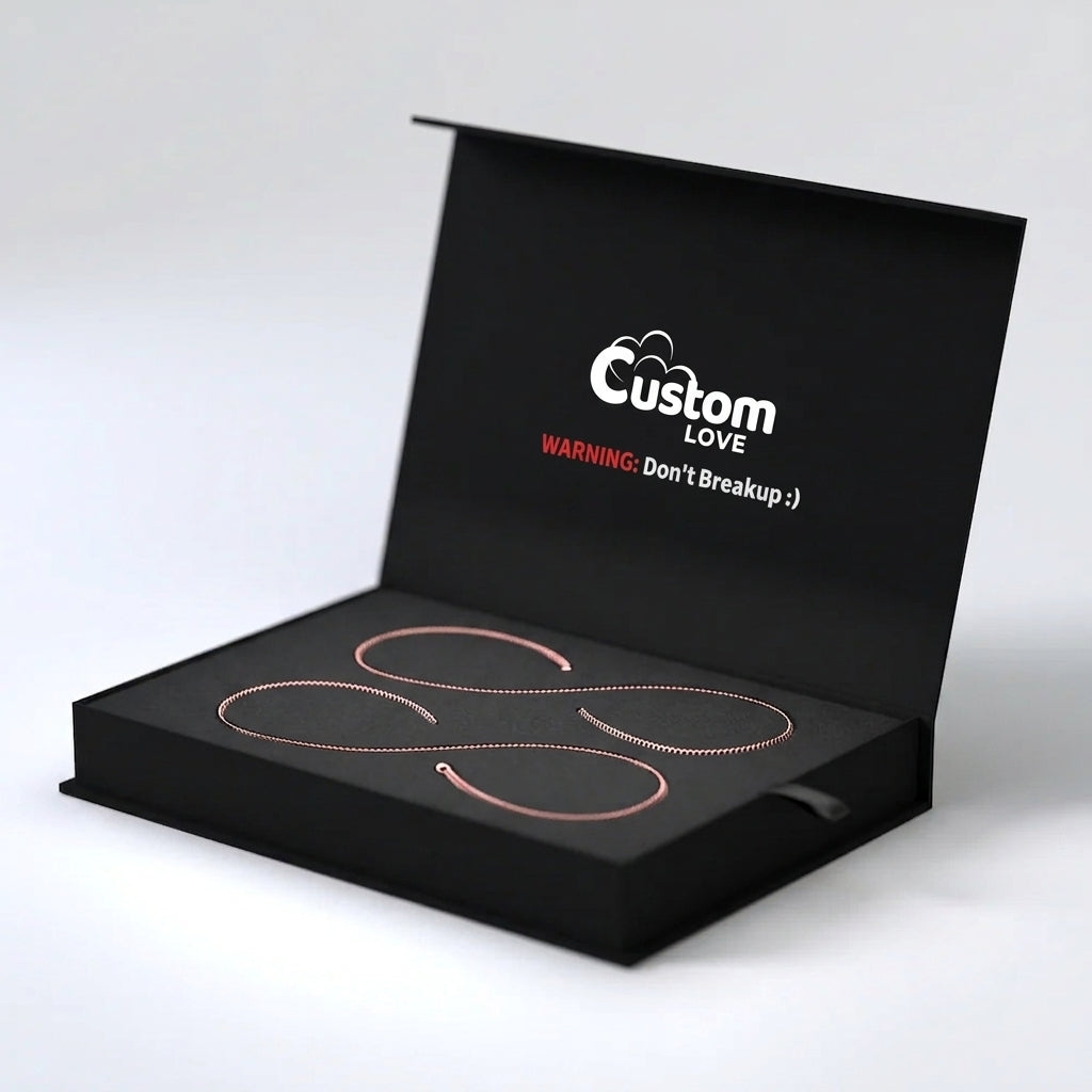 An open black presentation box on a light gray background, containing two thin rose gold heart-shaped rings. The inside lid features the white and red text 'Custom LOVE WARNING: Don't Breakup :)' in a humorous breakup-themed design.