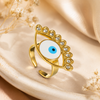 Gold ring with an eye design on a beige fabric background