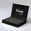 An open black presentation box on a light gray background, containing three curved metal bar pieces in gold and silver tones. The inside lid is printed with the words 'Custom LOVE' and a red warning, 'Warning: Don't Breakup :)'.